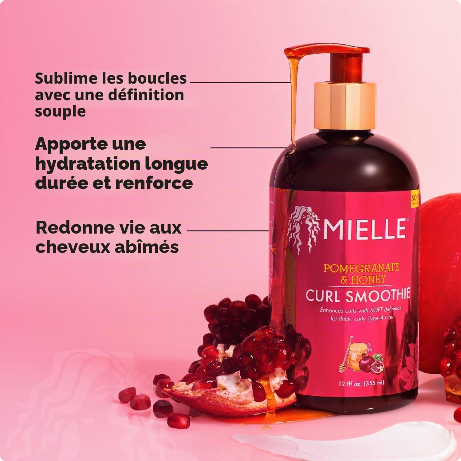 Mielle Pomegranate & Honey Curl Smoothie dans une bouteille foncée avec pompe. Morceaux de grenade à côté.