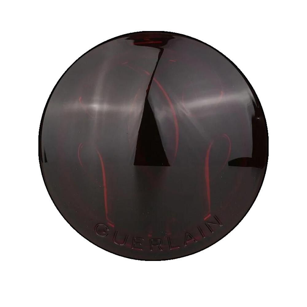 Boîtier rond de poudre compacte marron. Couvercle avec inscription Guerlain. Surface brillante.
