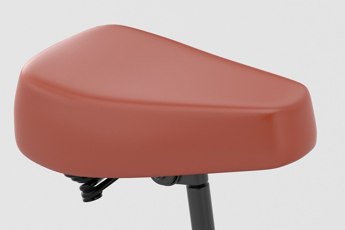 Selle de vélo marron. Support noir. Suspension visible. Gros plan.