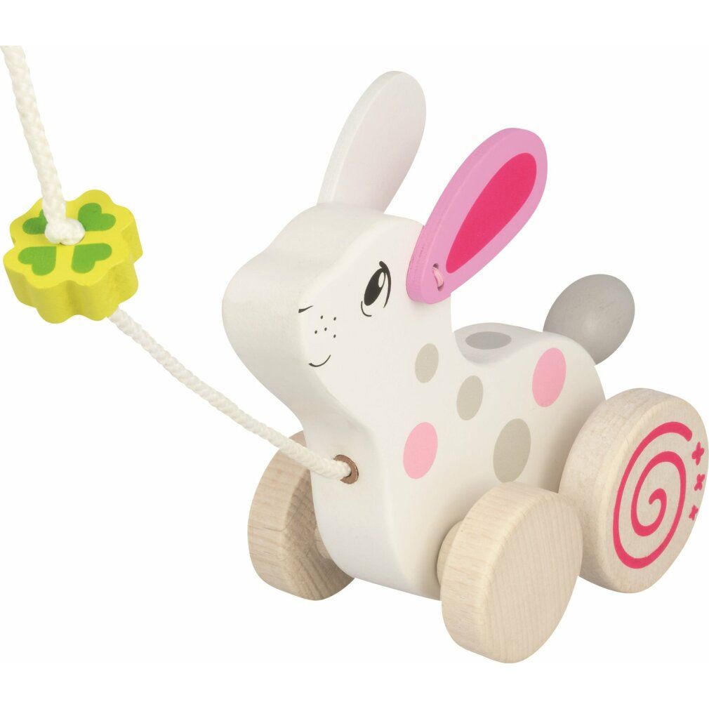 Jouet en bois en forme de lapin à tirer. Blanc avec pois roses et gris. Trèfle sur la ficelle.