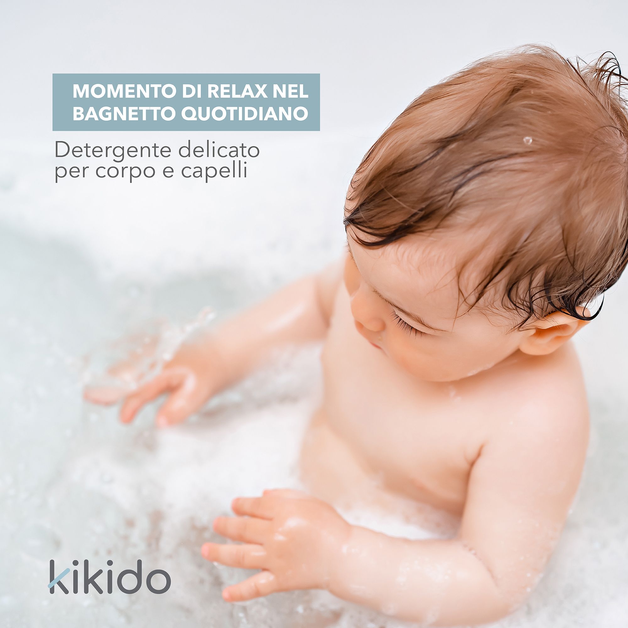 Baby in bad met schuim. Tekst: Kikido, Detersivo delicato per corpo e capelli.