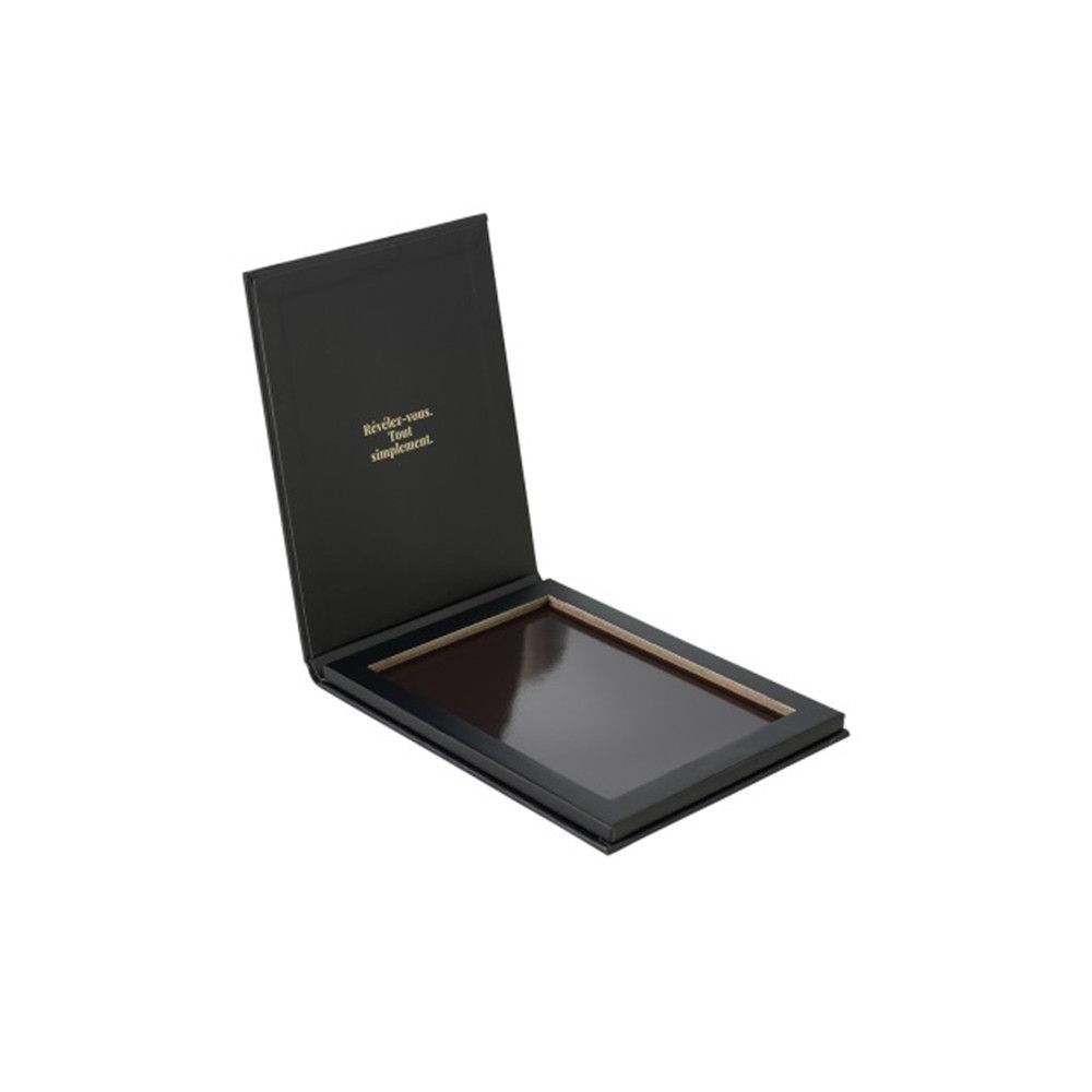 Palette noire ouverte. Cadre intérieur pour fards à paupières. Couvercle avec texte. Aucune marque visible.