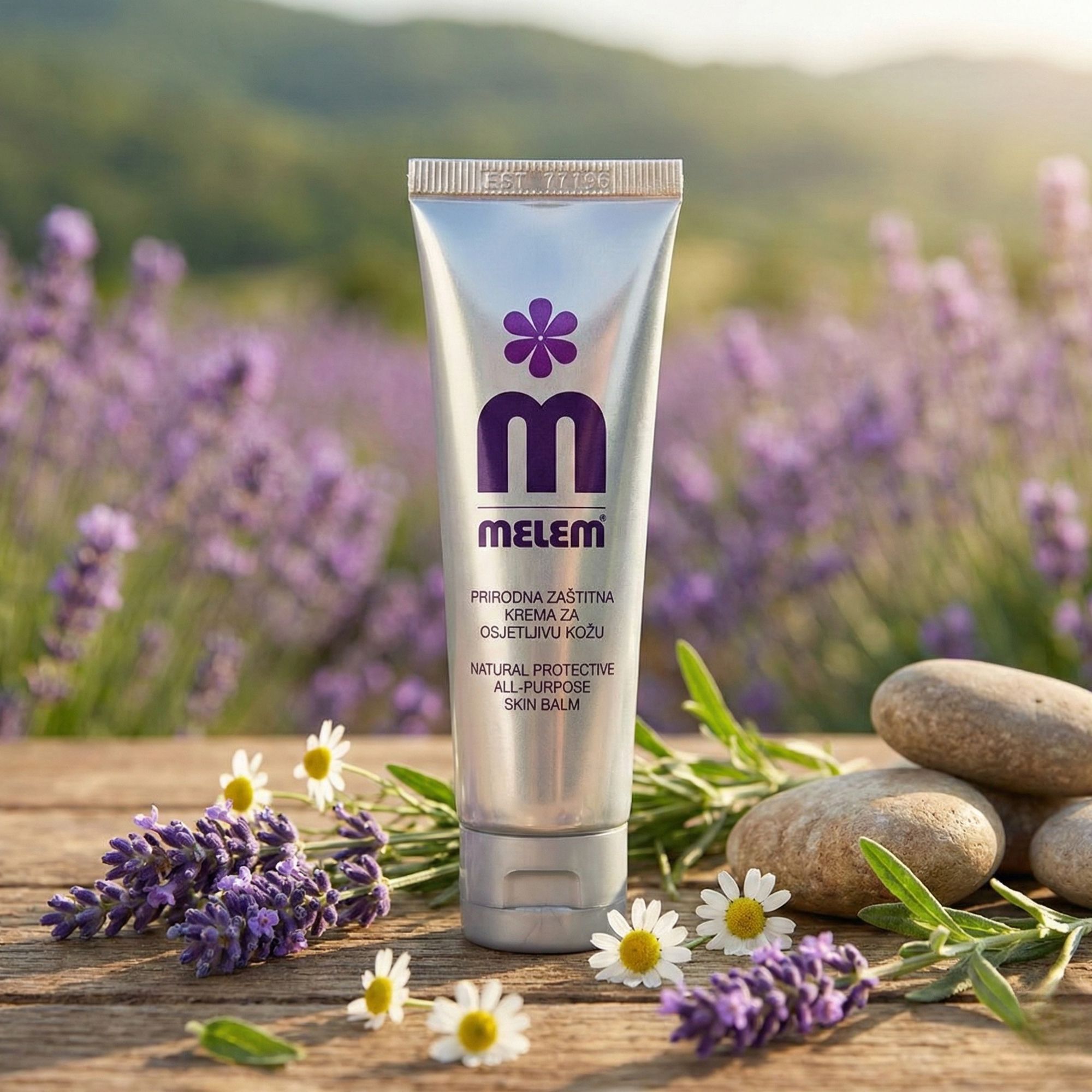 Tube argenté avec logo violet et texte MELEM sur bois. Environnement : lavande, pierres, marguerites.