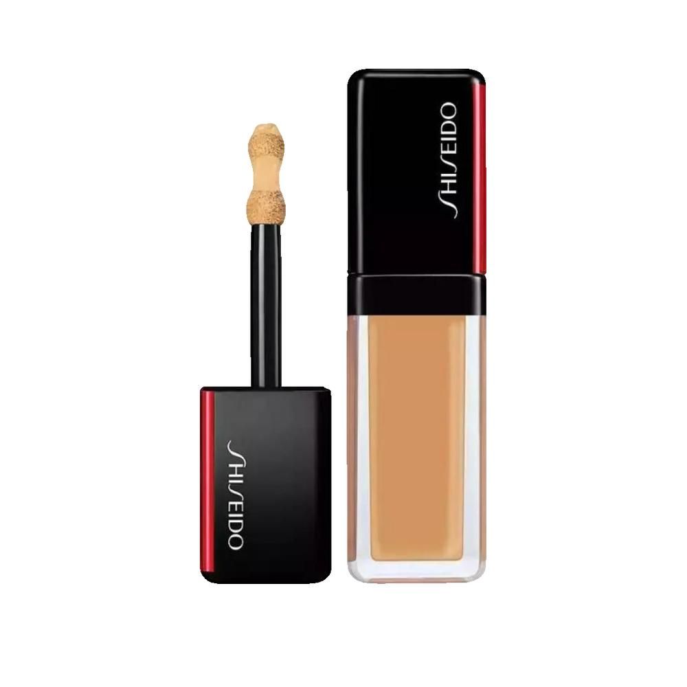 Produit cosmétique avec applicateur. Capuchon noir avec accent rouge et lettrage blanc Shiseido. Récipient contenant un liquide beige.