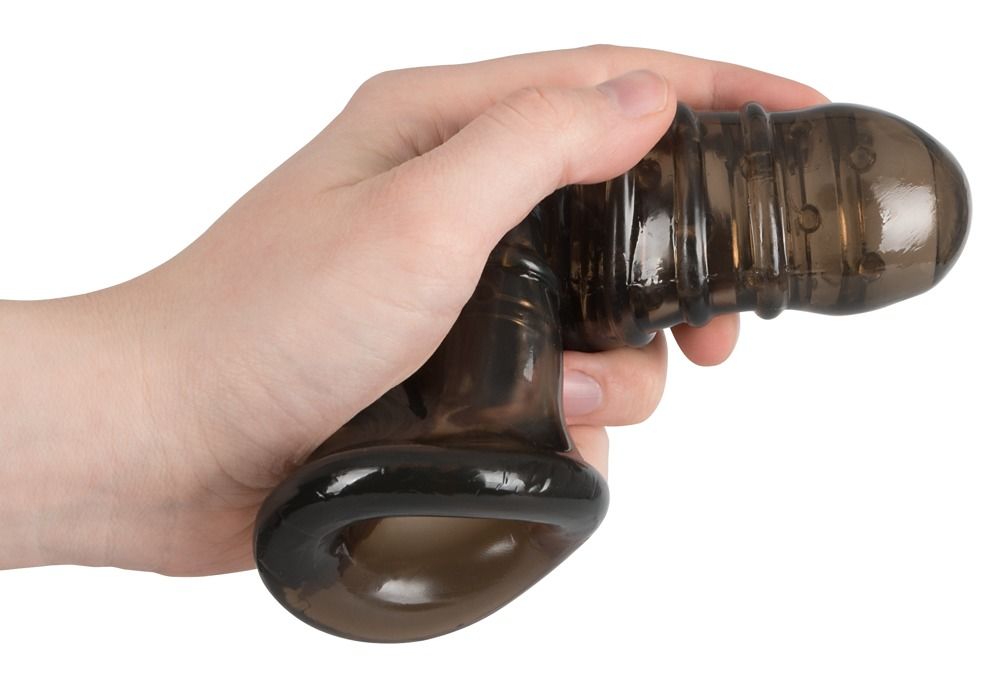 Zwarte penishoes met opening voor de testikels in hand. Geribbelde oppervlakte, opening aan het uiteinde.