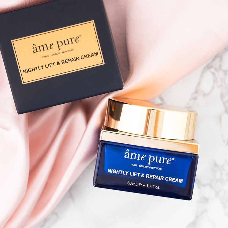 Een potje âme pure Nightly Lift & Repair crème naast een geopende doos. Blauw glazen potje met gouden deksel.