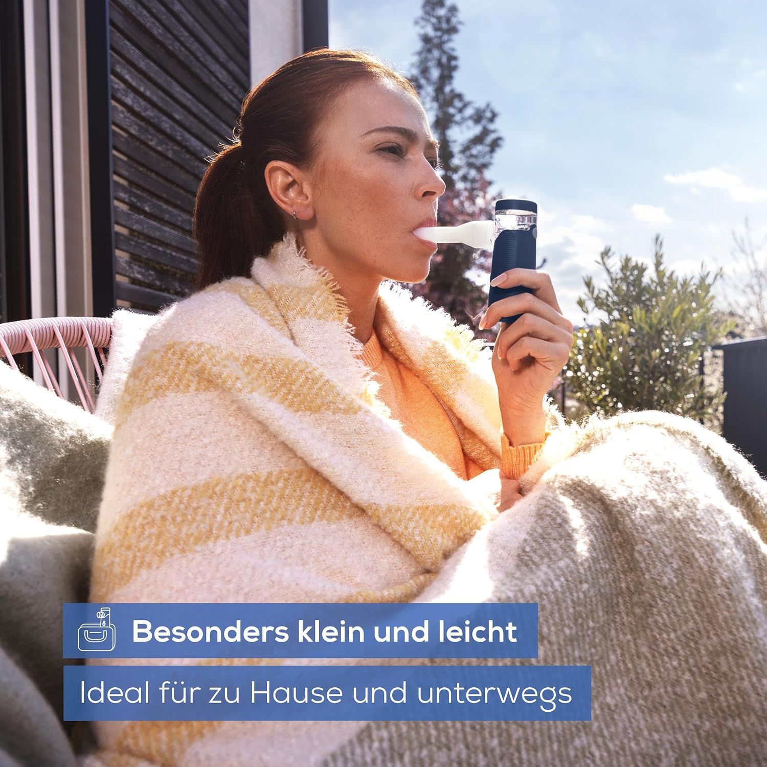 Personne utilisant un inhalateur bleu. Texte: Particulièrement petit et léger. Idéal pour la maison et les déplacements.