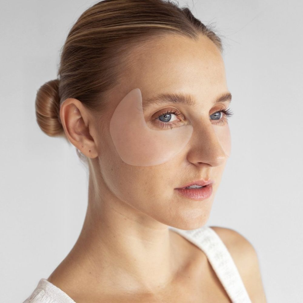 Femme avec un APRICOT Eye-Temple Pad sur la peau. Pad couleur peau sur l'œil.