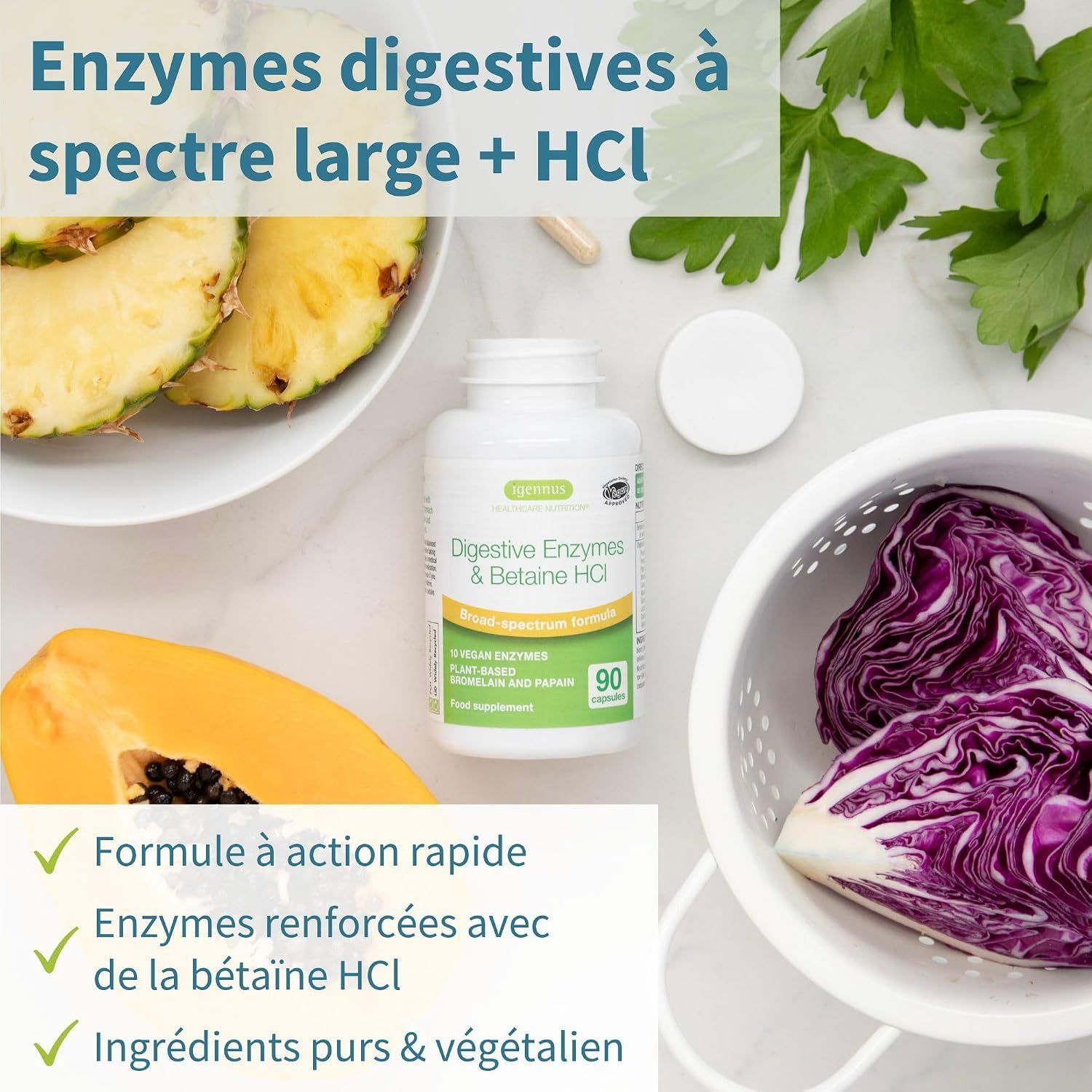 Bouteille d'enzymes digestives et de bétaïne HCl, à côté d'ananas, de papaye et de chou rouge.