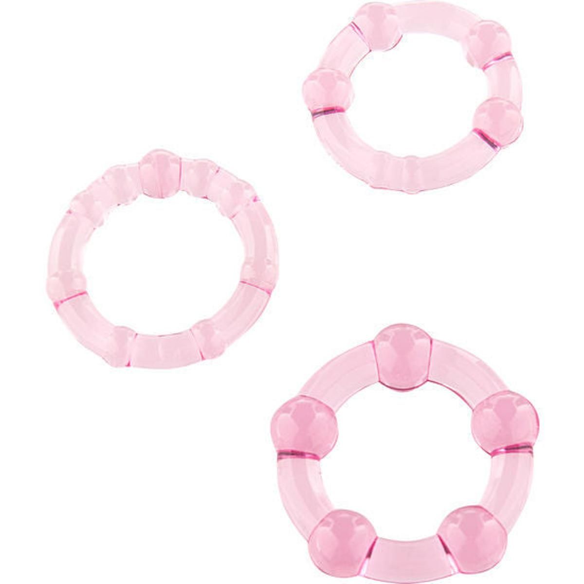 Trois anneaux de pénis roses de différentes tailles et designs.