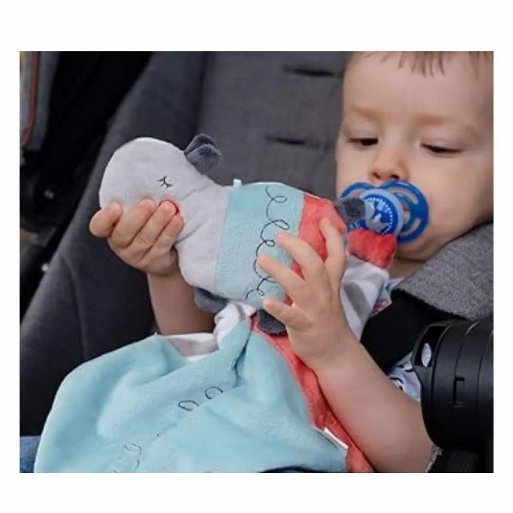 Enfant dans une poussette avec doudou et tétine. Tête d'hippopotame, tissu bleu.