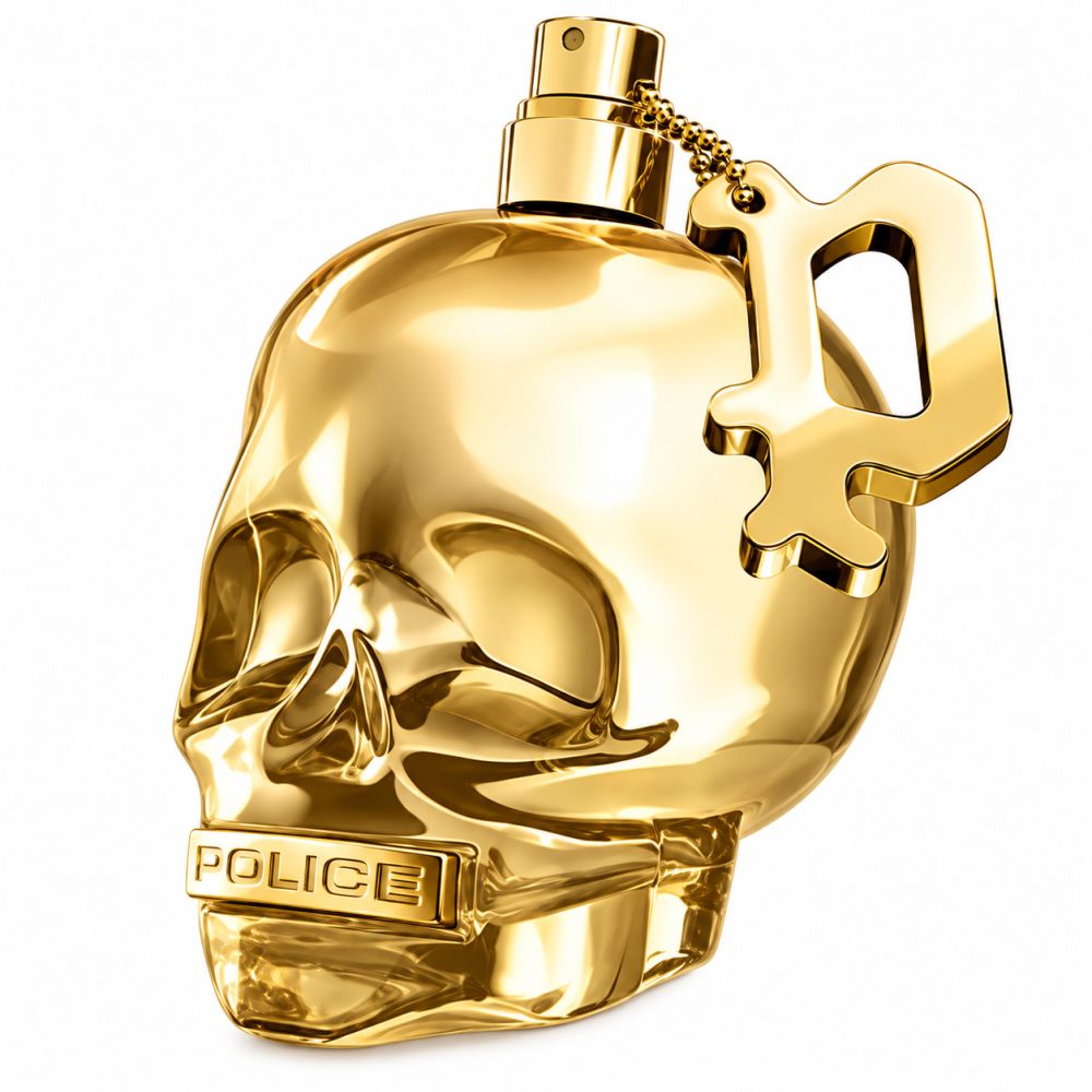Flacon de parfum doré en forme de tête de mort avec un pendentif.