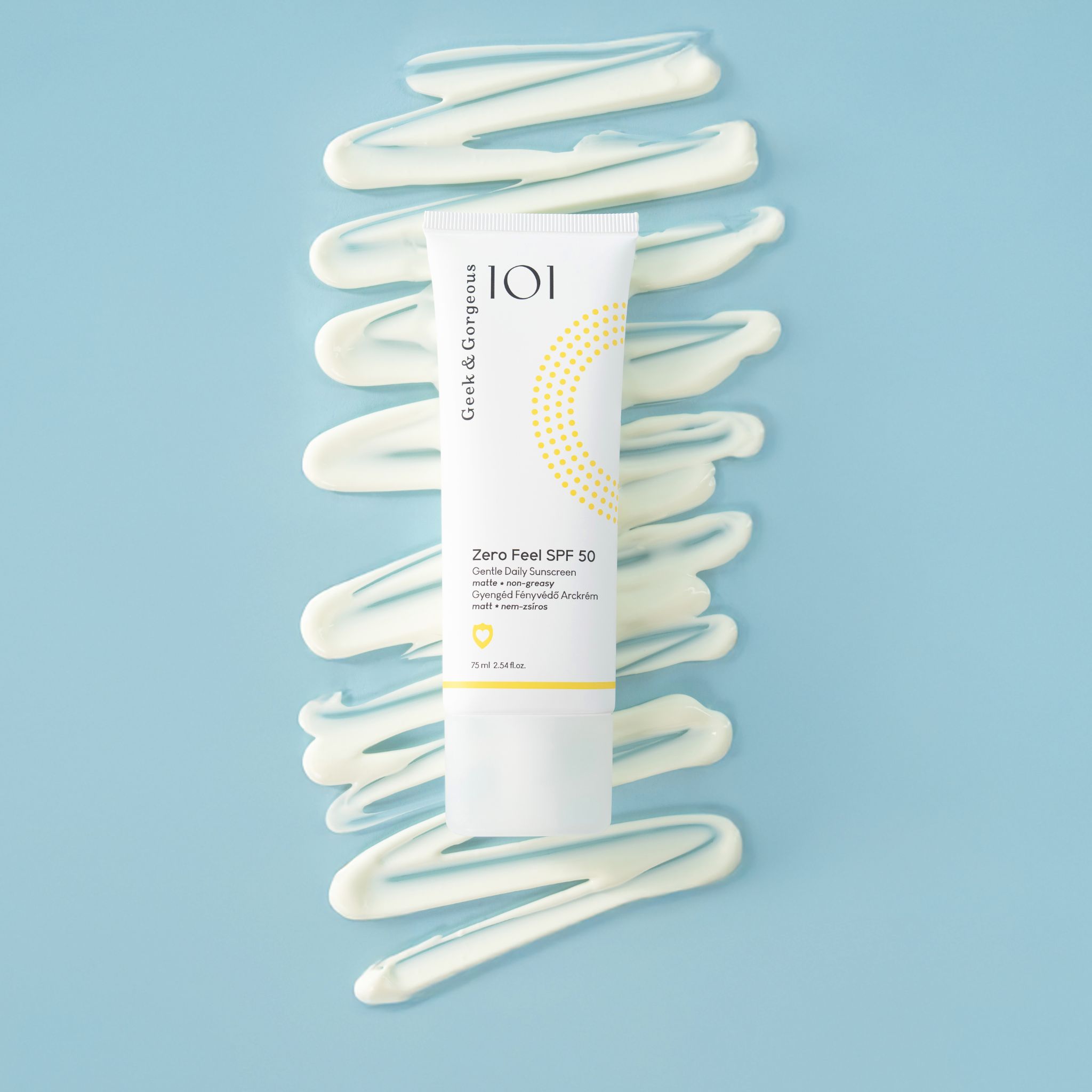 Tube blanc "Zero Feel SPF 50" sur fond bleu avec des traits blancs. Marque : Geek & Gorgeous.