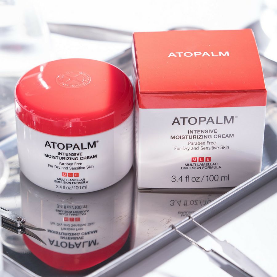 Crème pot en doos. Opschrift: ATOPALM INTENSIVE MOISTURIZING CREAM. Voor droge en gevoelige huid. Op dienblad.