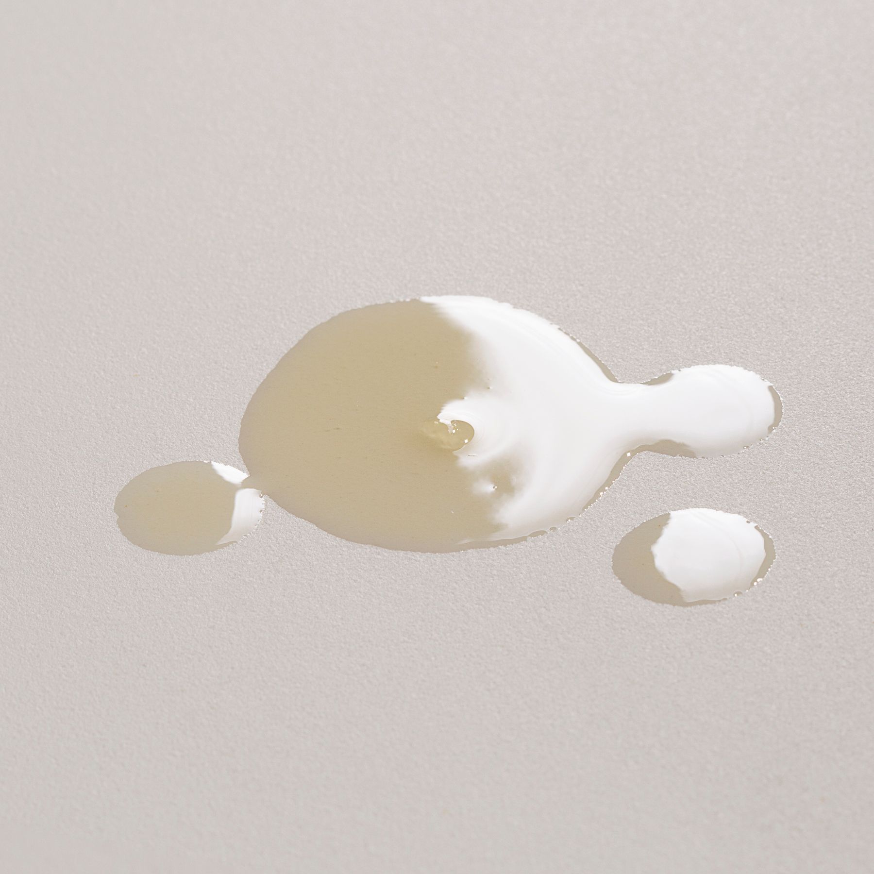 Une goutte d'huile dorée sur fond clair.