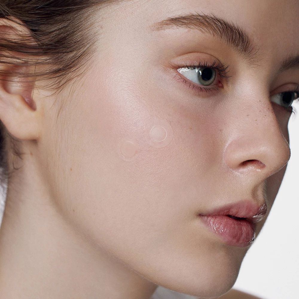 Gezicht van een persoon met een transparante, ronde patch op de huid. Close-up.