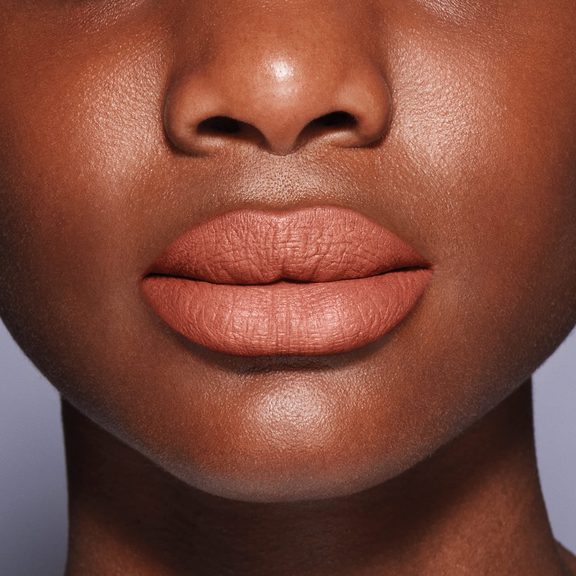 Gros plan sur les lèvres. Rouge à lèvres nude. Teint foncé.