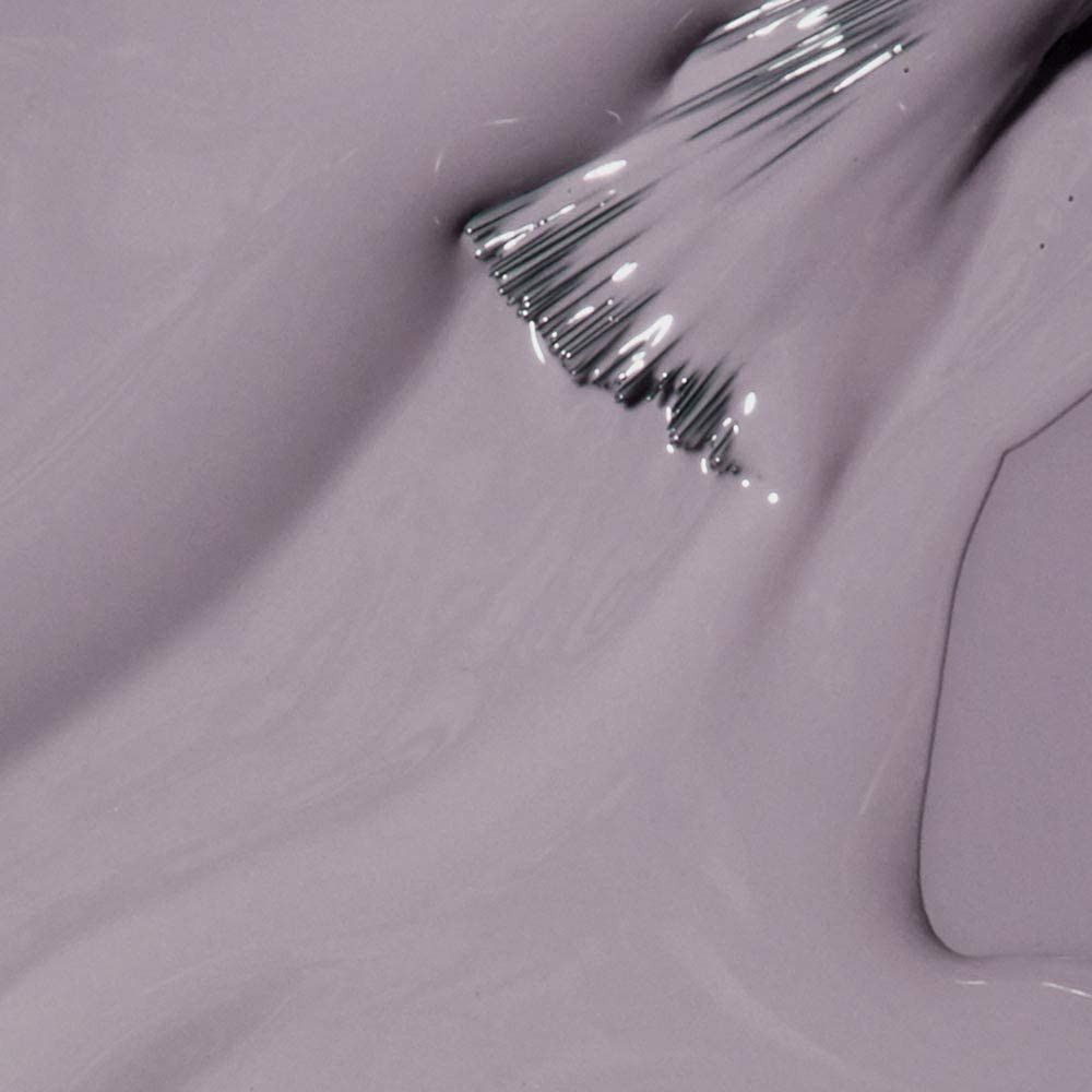 Vernis à ongles lilas clair. Pointe du pinceau avec vernis sur surface lisse. Gros plan.