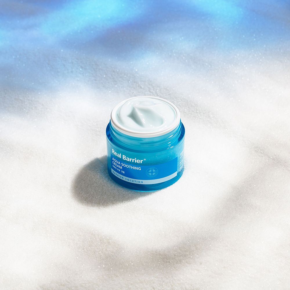 Pot de crème ouvert sur fond blanc. Inscription "Real Barrier Aqua Soothing Cream".