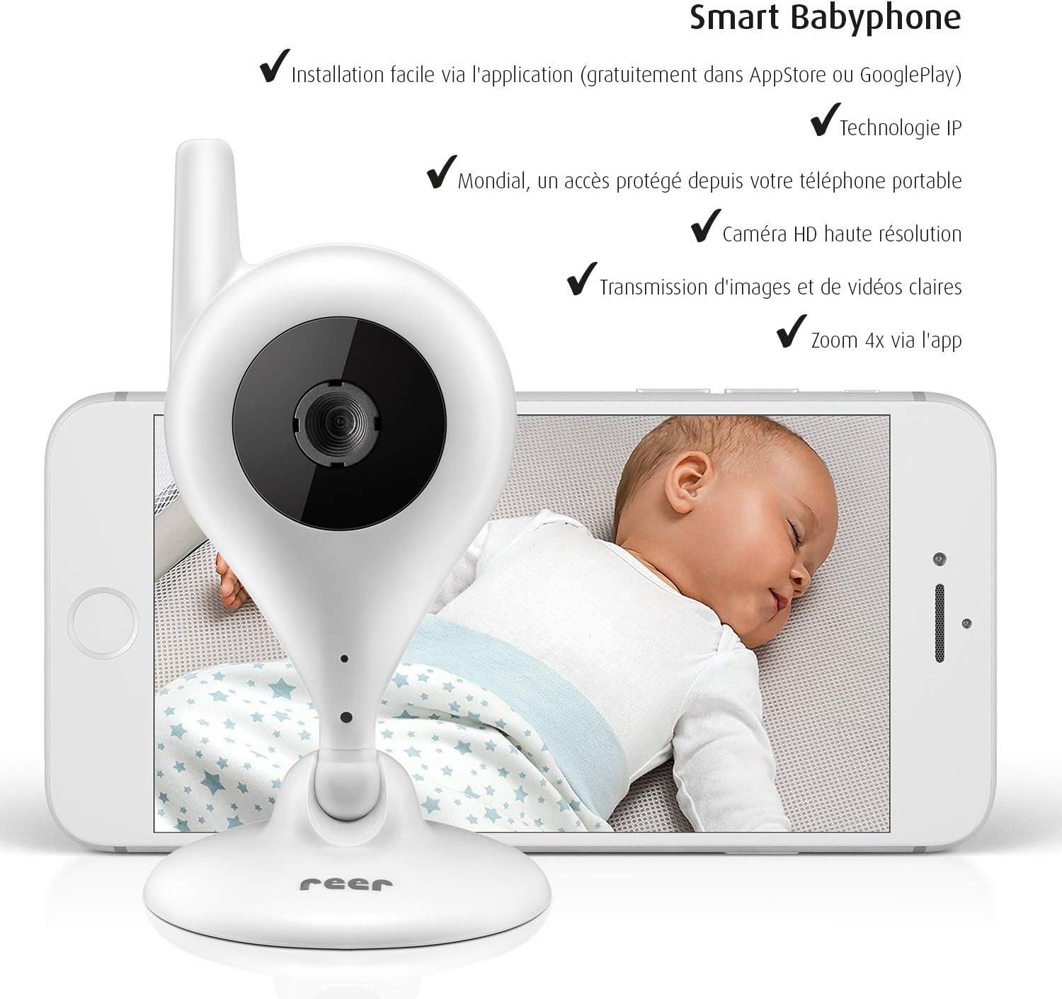 Caméra bébé blanche avec tête pivotante et microphone intégré, devant un smartphone affichant un bébé endormi.