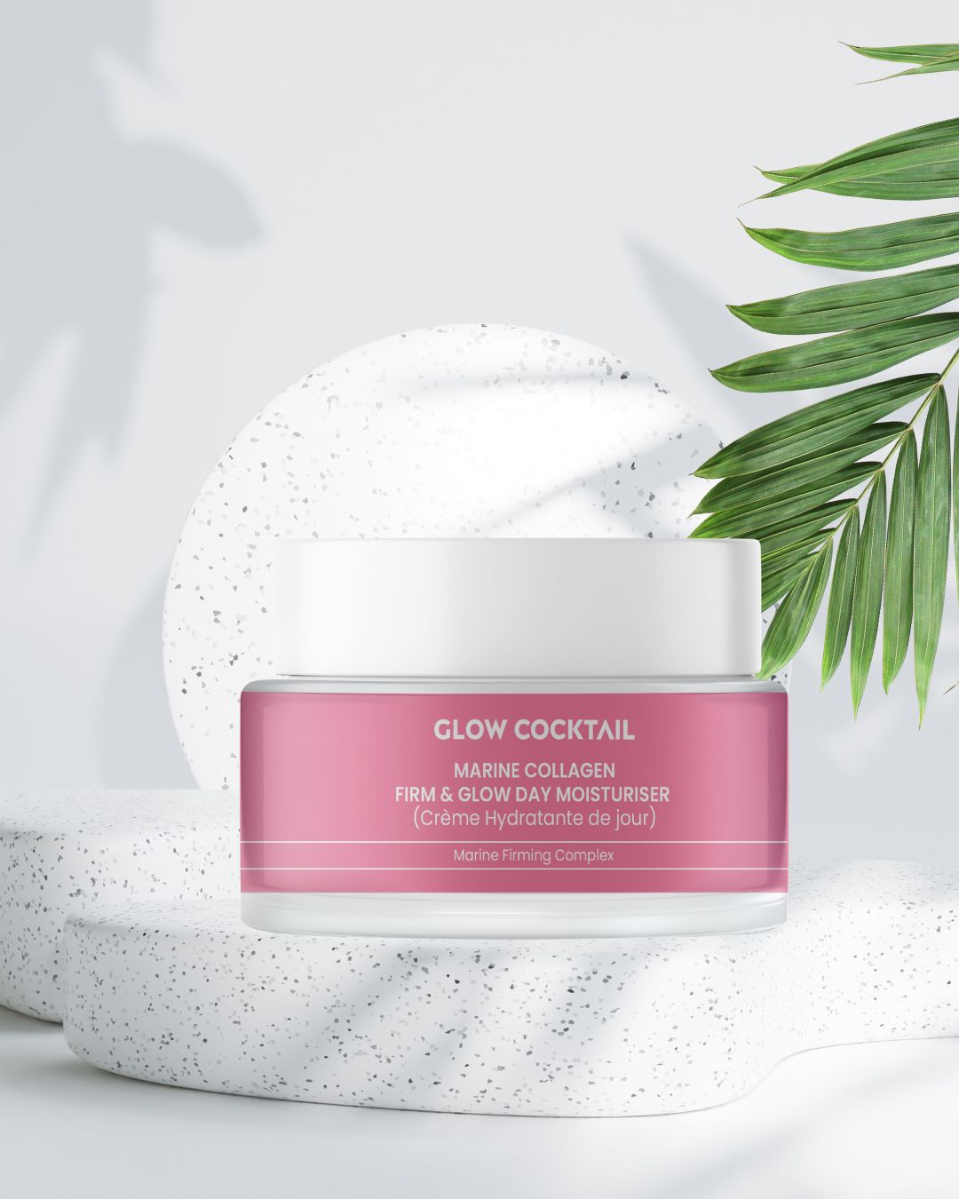Pot de crème rose avec couvercle blanc sur socle. Inscription: Marine Collagen Firm & Glow Day Moisturiser. Marque: Glow Cocktail.