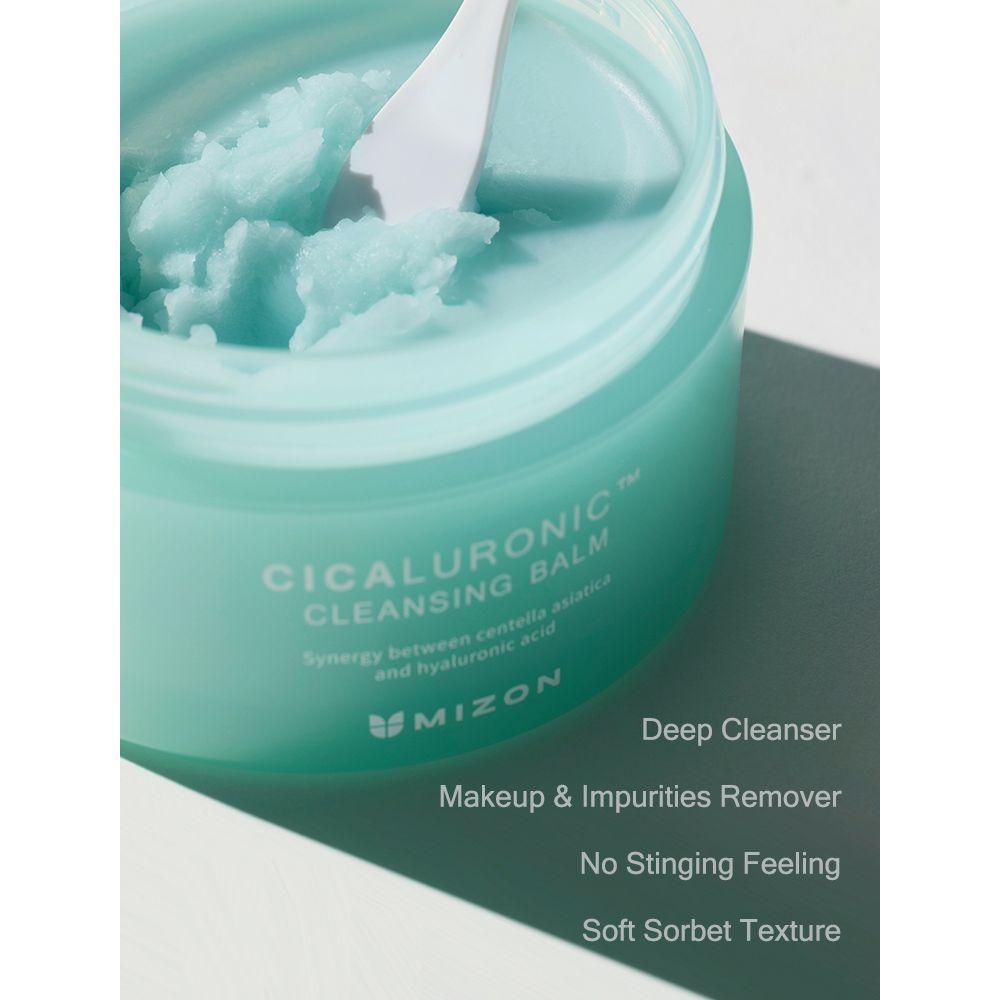 Open turquoise pot met witte deksel. Product met spatel. Opschrift: CICALURONIC CLEANSING BALM. Merk: Mizon.