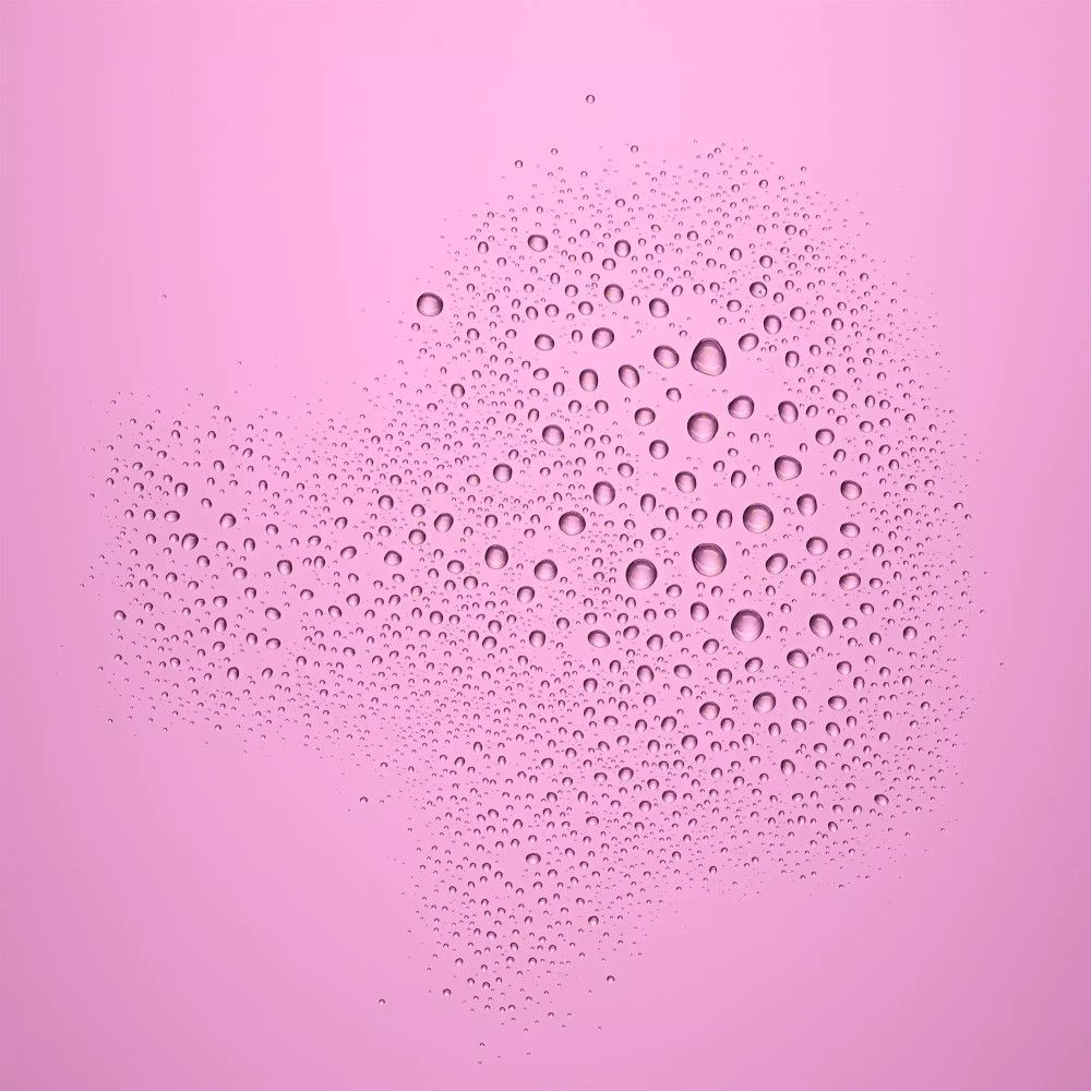 Fond rose avec de nombreuses petites gouttelettes d'eau. Les gouttes forment une forme irrégulière.