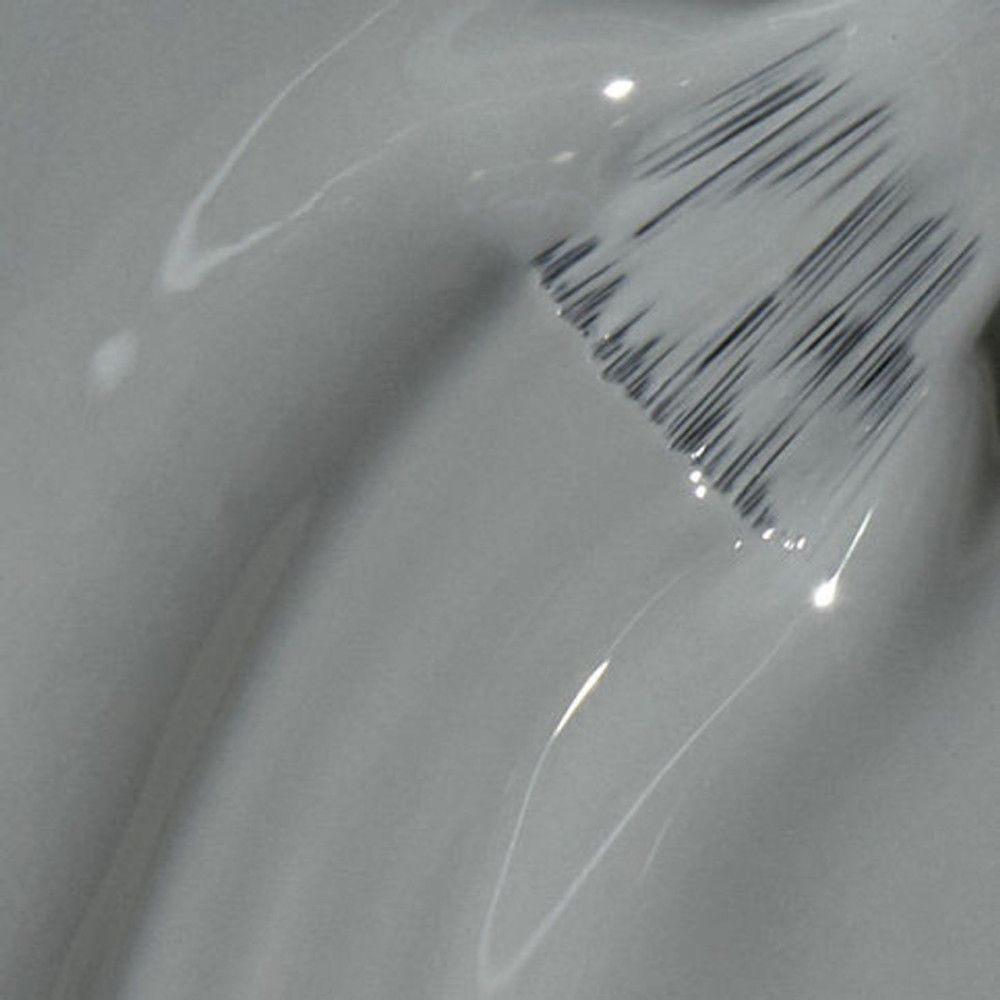 Applicateur de vernis à ongles gris. Détail des poils visible. Surface brillante.