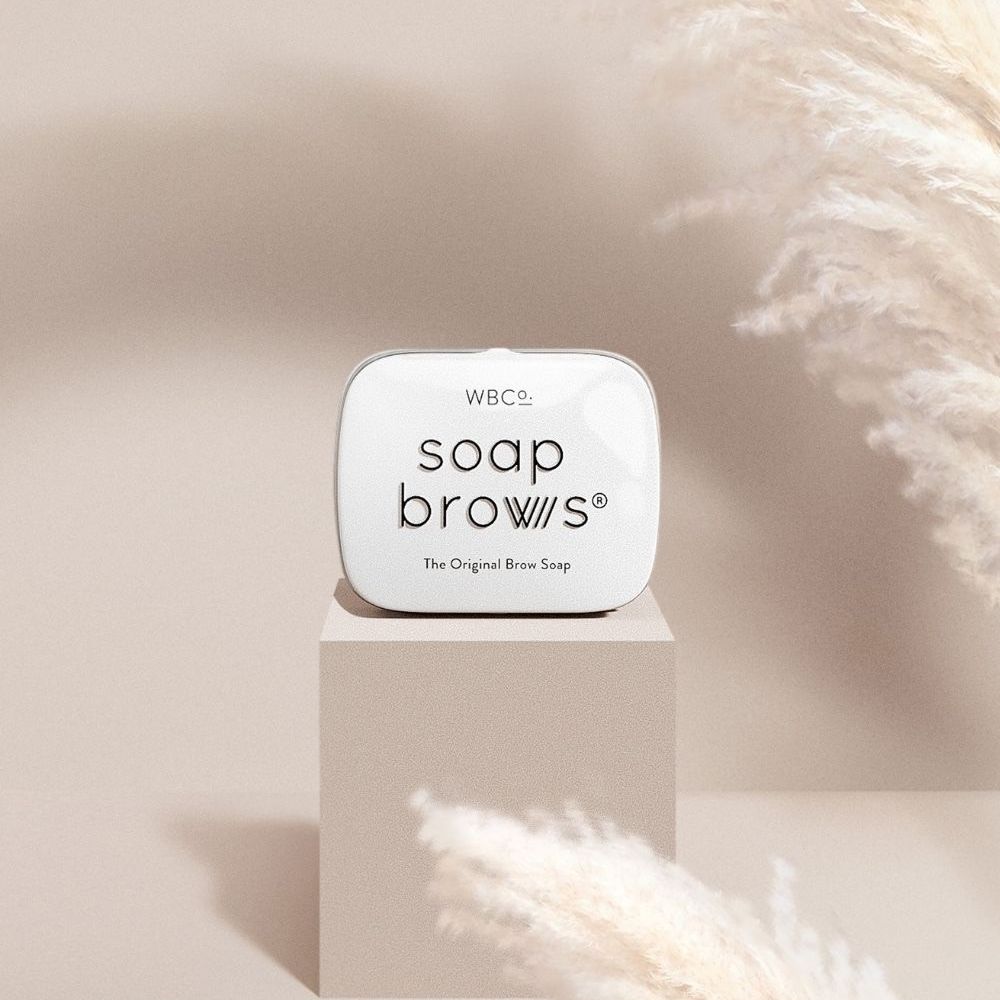 Witte doos met tekst op een sokkel. Achtergrond met pampasgras.