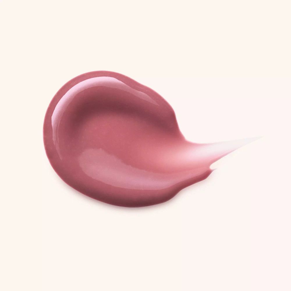 Roze lipgloss laag op lichte achtergrond. Glanzende textuur.