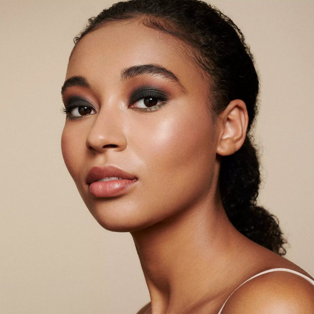 Portret van een vrouw met donkere make-up. Donker opgemaakte ogen, roze lippen, lichte teint.