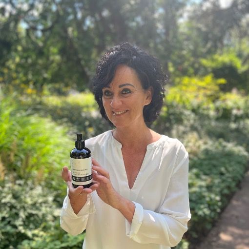 Une femme tient un flacon de gel nettoyant. Texte : Intensive Face Cleansing Gel, Vegan, IFC, Cosmos Organic.