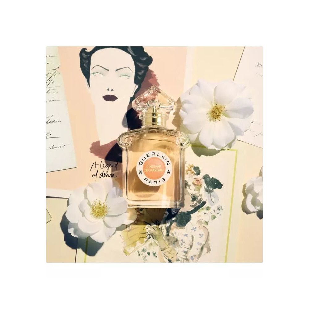 Parfumfles met rond etiket en tekst. Op papier met bloemen en tekeningen. Witte bloemen.