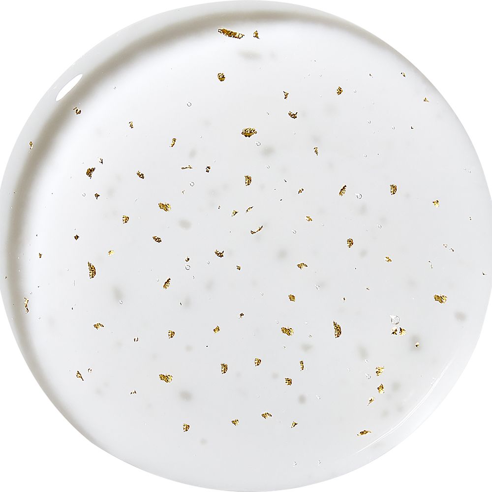 Gros plan circulaire d'un liquide avec des particules dorées. Liquide clair avec de nombreux petits flocons d'or.