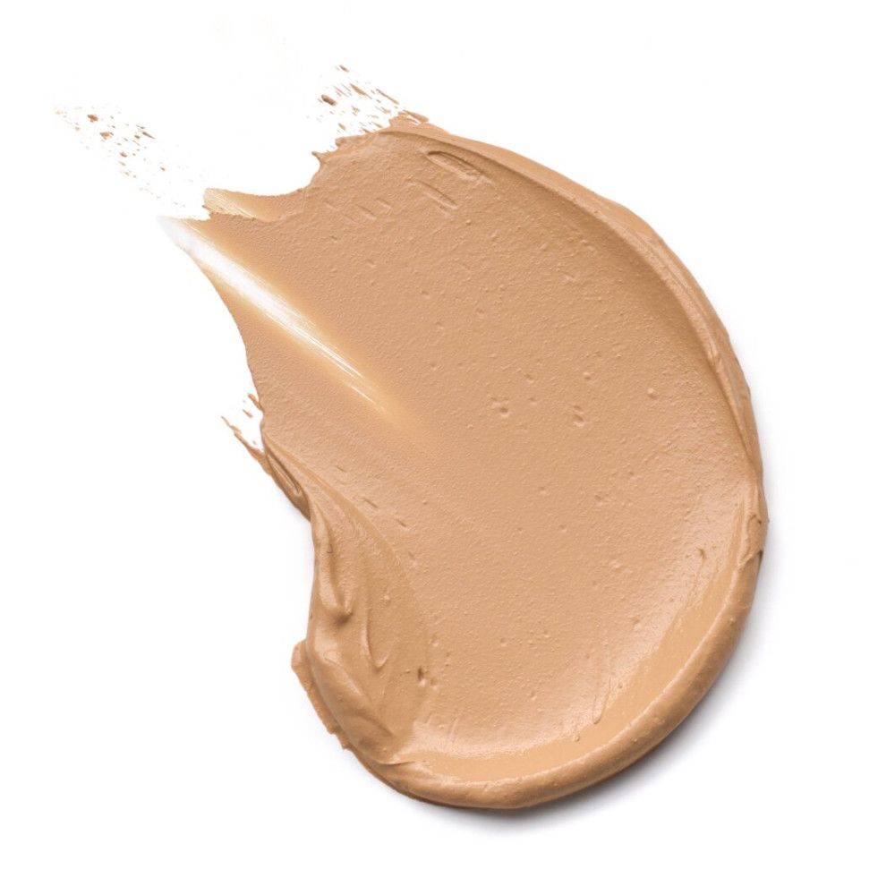 Un échantillon crémeux de fond de teint brun clair sur fond blanc. La texture est lisse et couvrante.