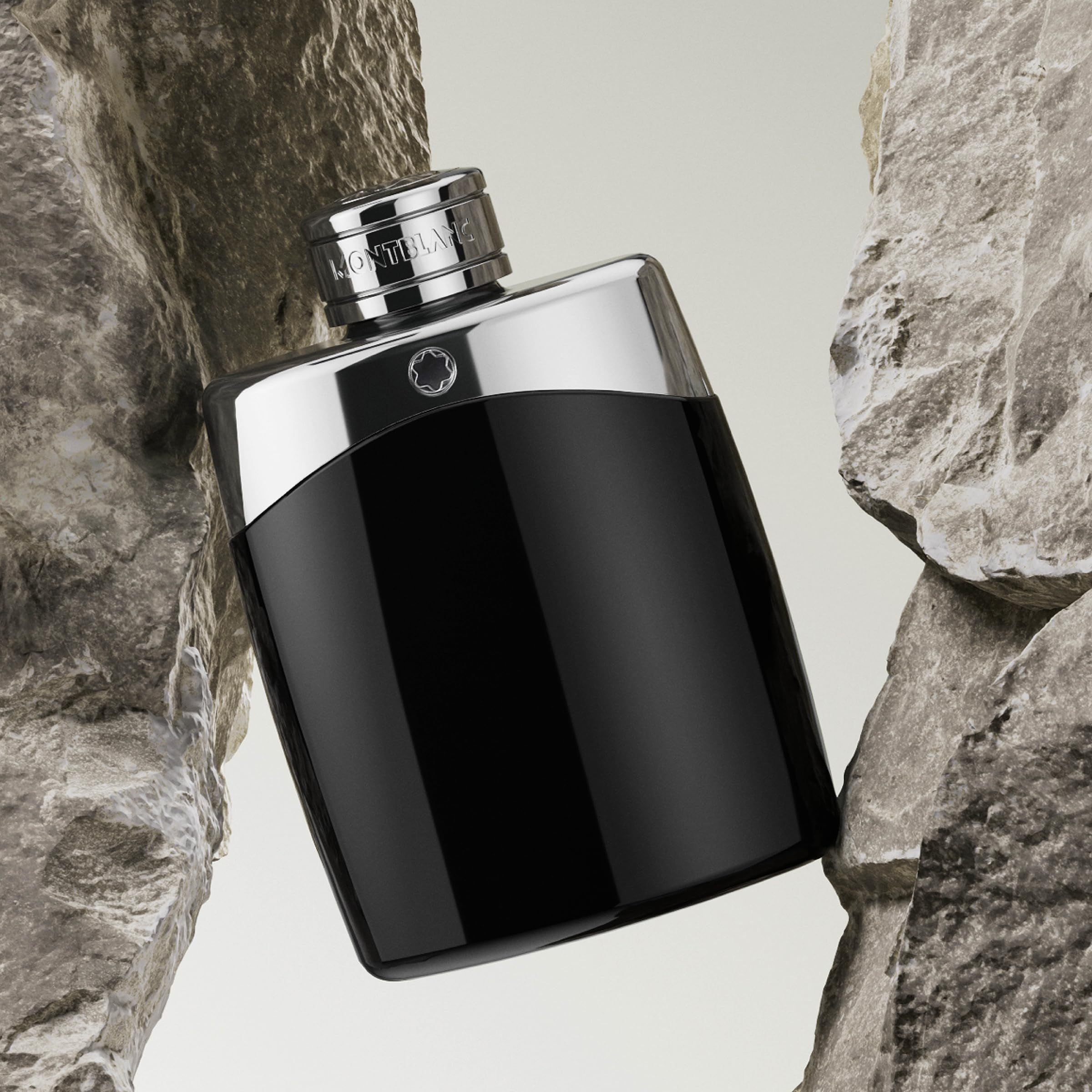 Zwarte fles met zilveren dop, geplaatst tussen stenen. Opschrift: MONTBLANC. Vorm: rechthoekig.