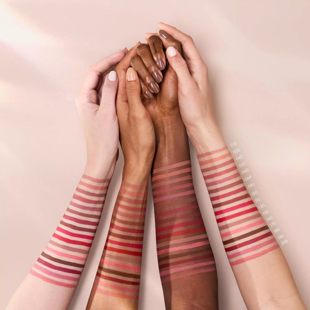 Armen met lippenstiftkleuren op de huid. Verschillende huidtinten.