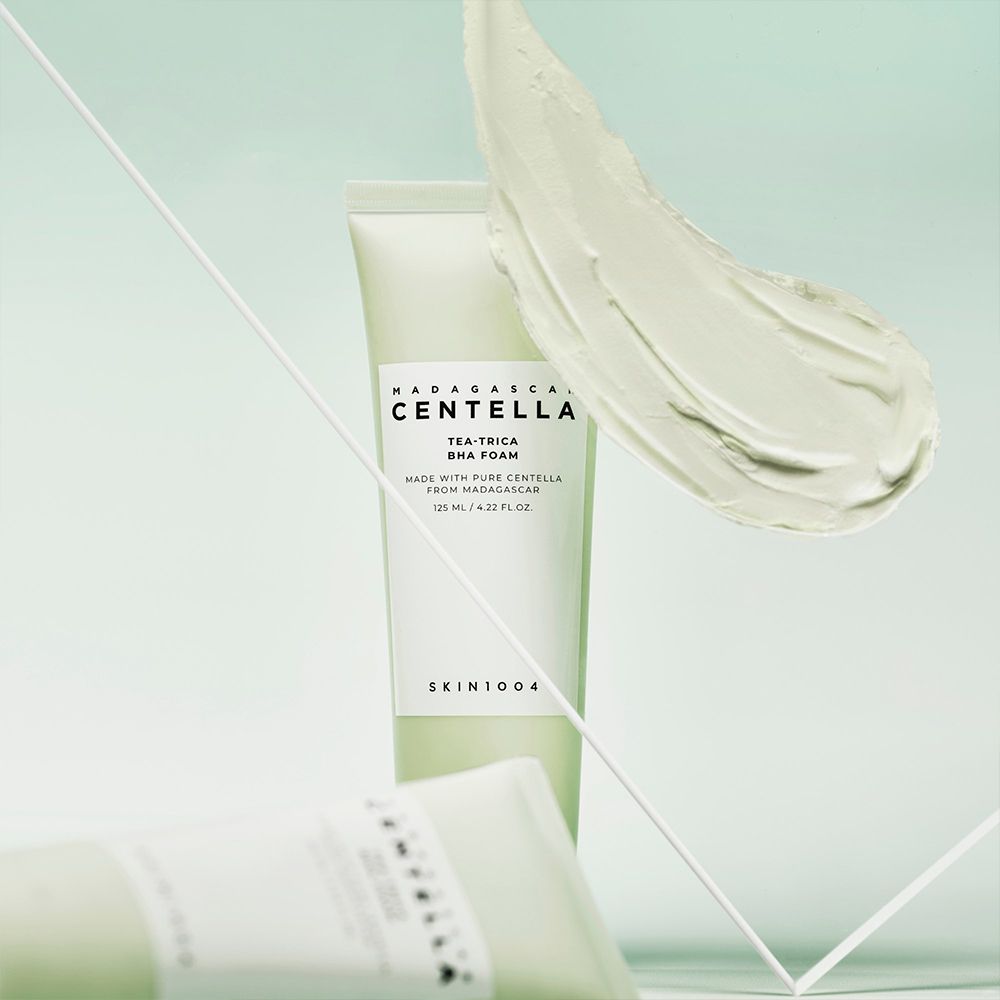 Tube vert avec étiquette blanche, entouré de texture crémeuse et de lignes géométriques.