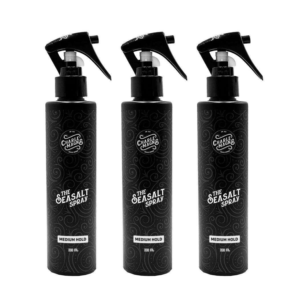 Drie zwarte spuitflessen met opschrift "The Seasalt Spray" en "Medium Hold".