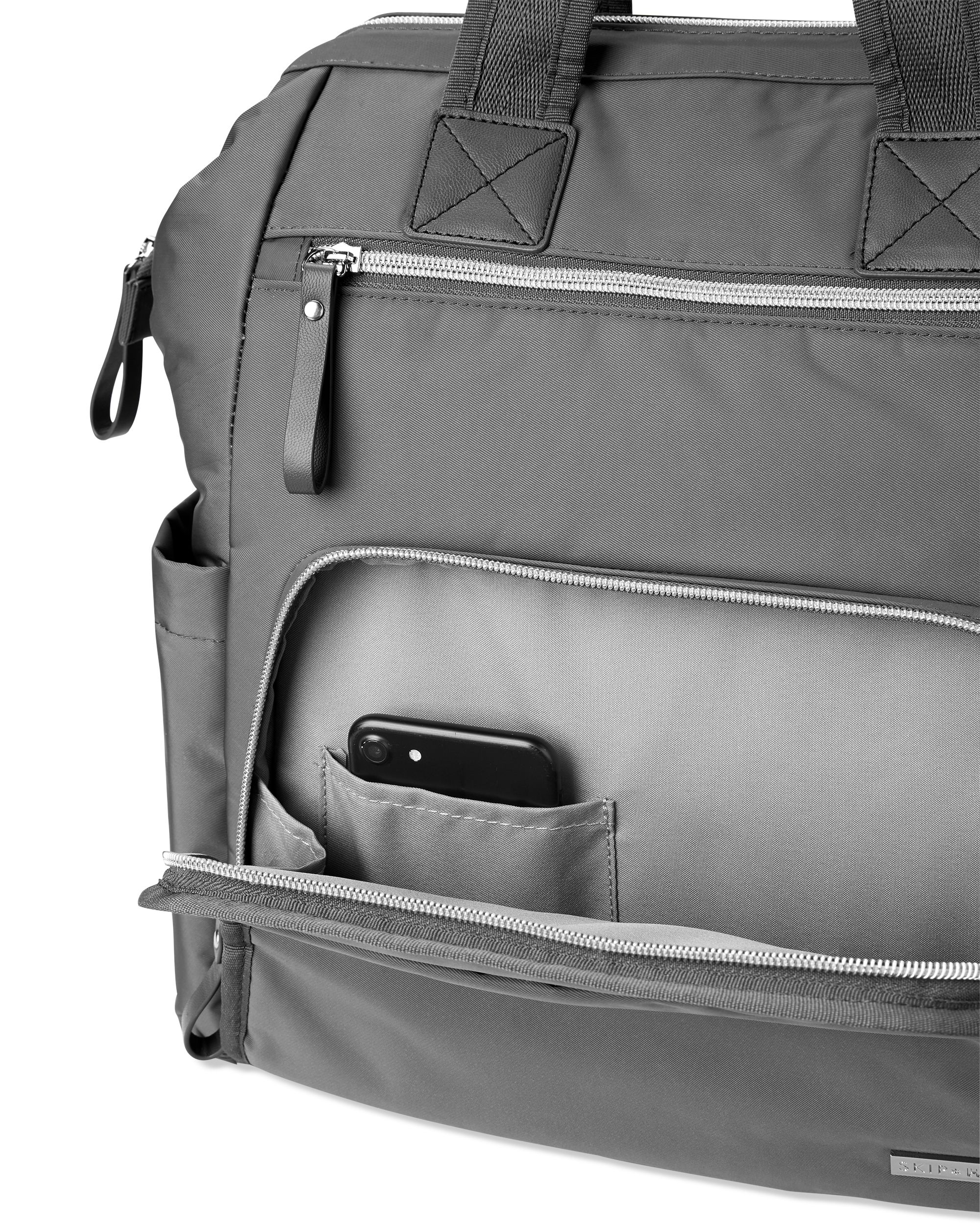 Grijze luiertas, detailweergave. Ritsvak met smartphone. Zwarte leren riem.