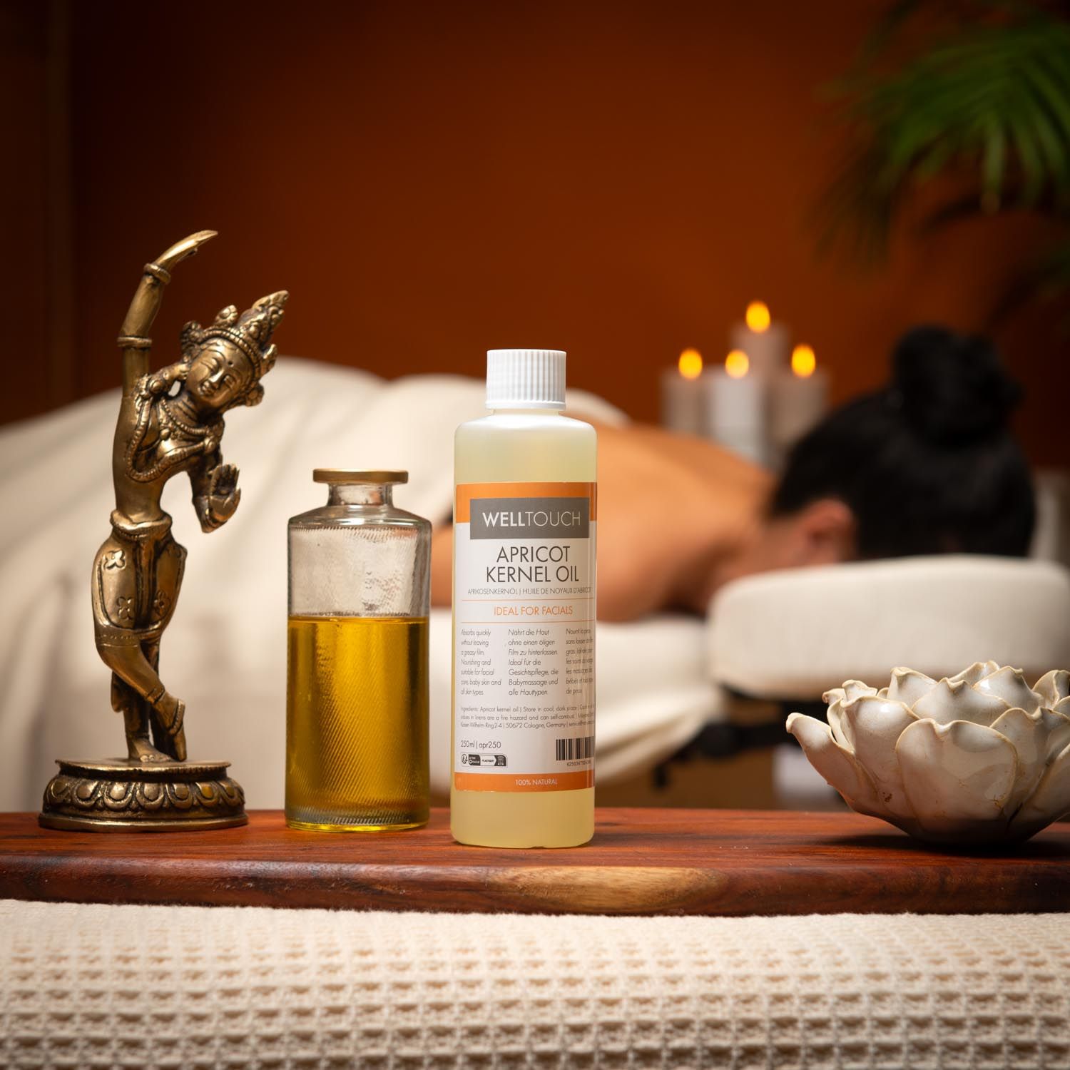 Flacon d'huile de noyau d'abricot Welltouch et flacon en verre sur plateau en bois. Massage. Décoration.