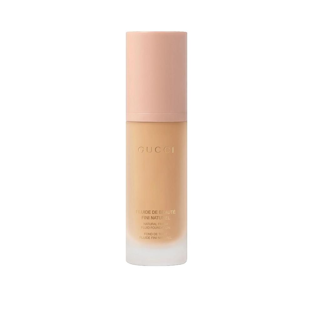 Flacon beige avec bouchon rose. Inscription Gucci. Nom du produit et informations sur le flacon.