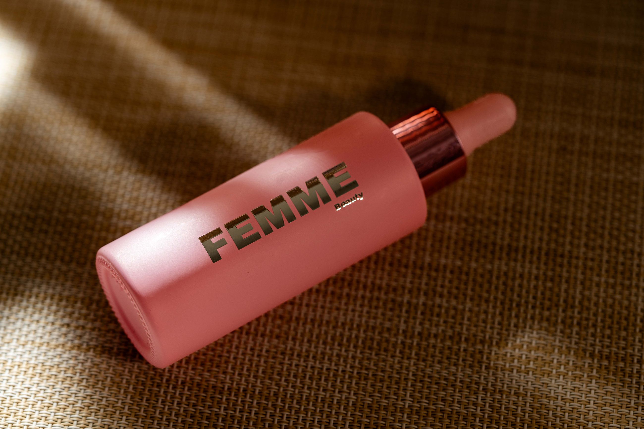 FEMME Advanced Repair Face Serum mit Propolis: Roze glazen flesje met pipet en roségouden dop.