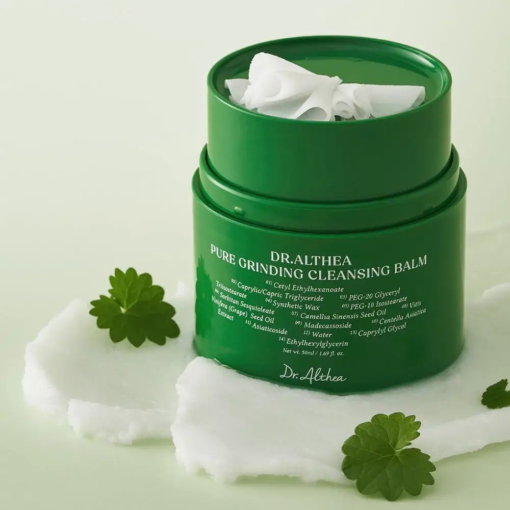 Contenant vert avec baume nettoyant blanc. Inscription : Pure Grinding Cleansing Balm. Couvercle avec lingettes blanches.