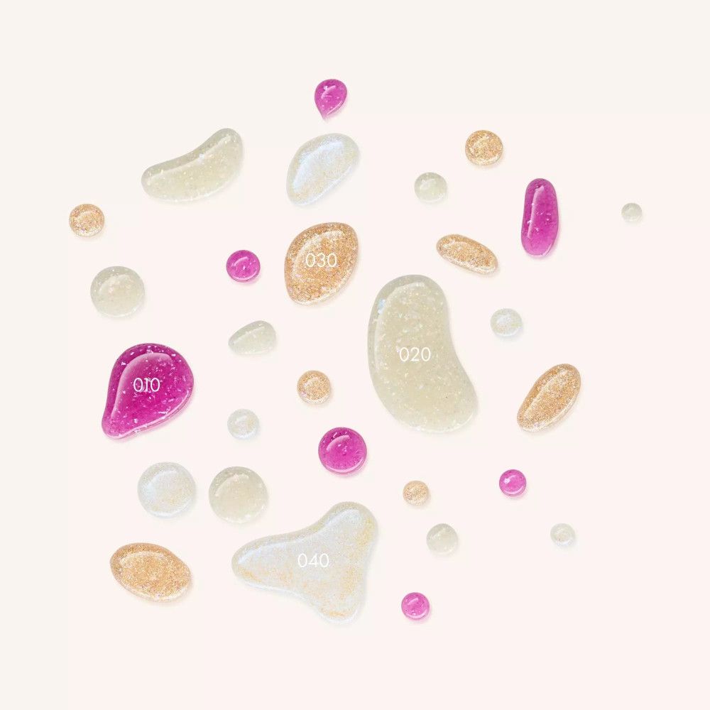 Diverses gouttes de vernis à ongles avec effet cristal concassé. Couleurs : rose, or, blanc. Quelques gouttes numérotées.