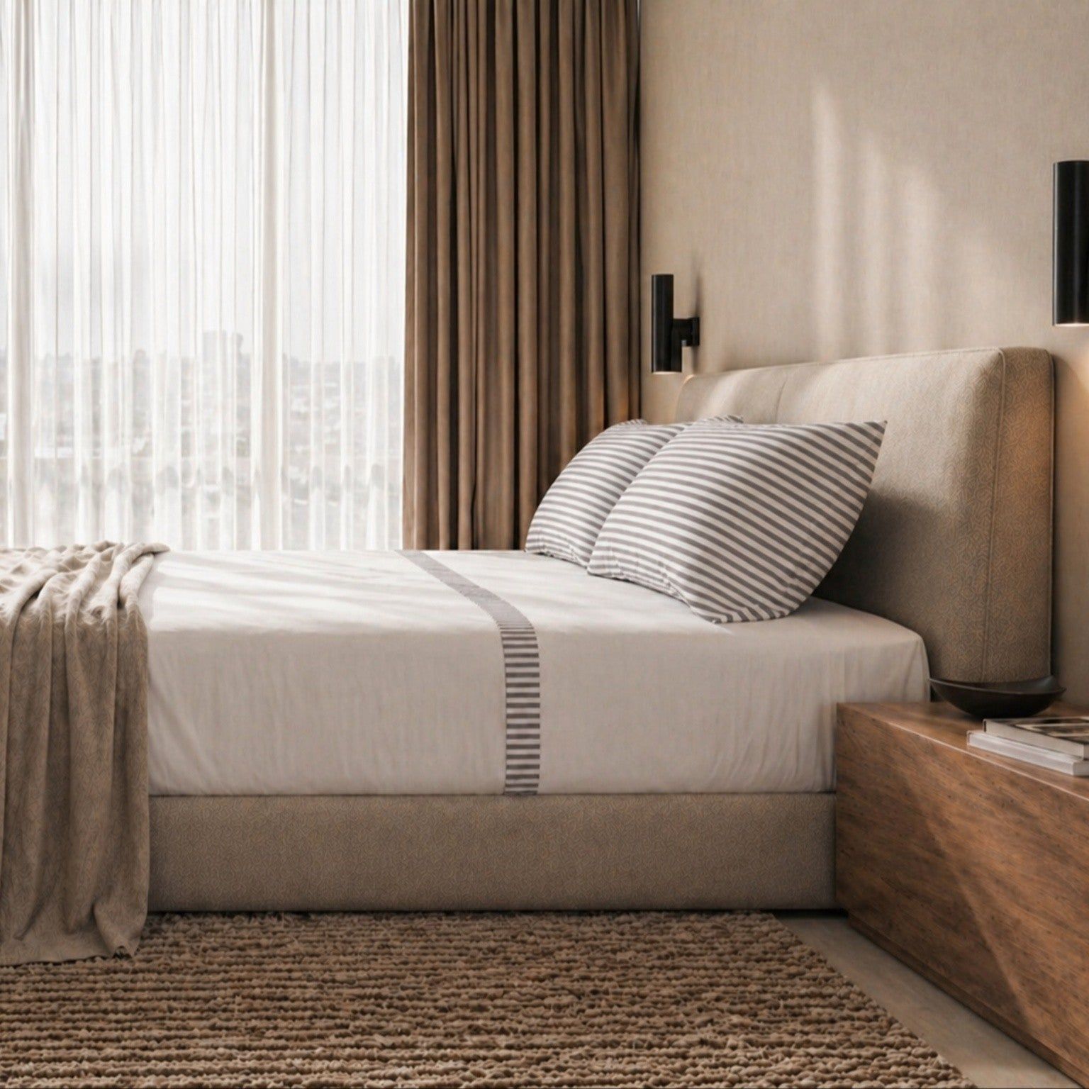 Opgemaakt bed met gestreepte kussenslopen en beddengoed.