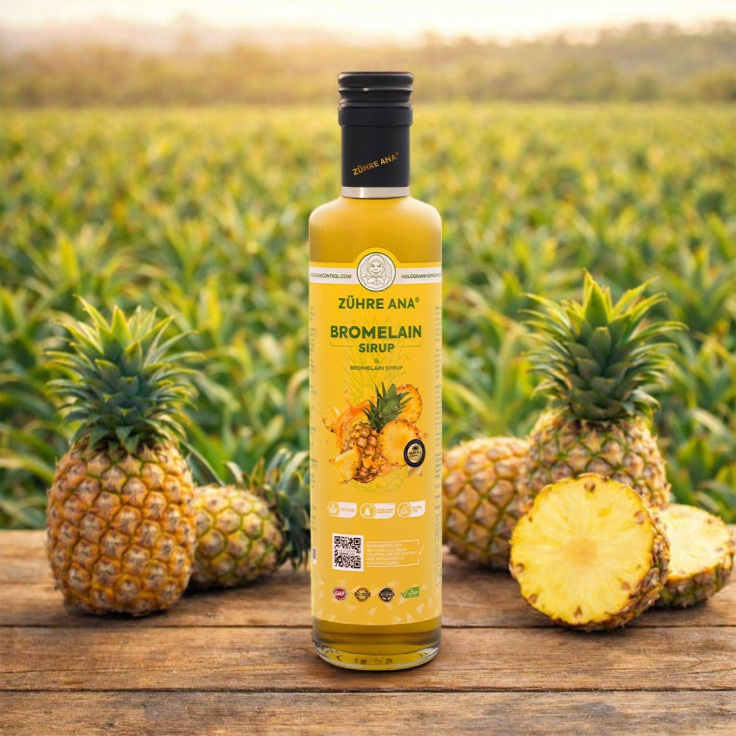 Bouteille de sirop de bromélaïne Zühre Ana sur une table en bois, entourée d'ananas.