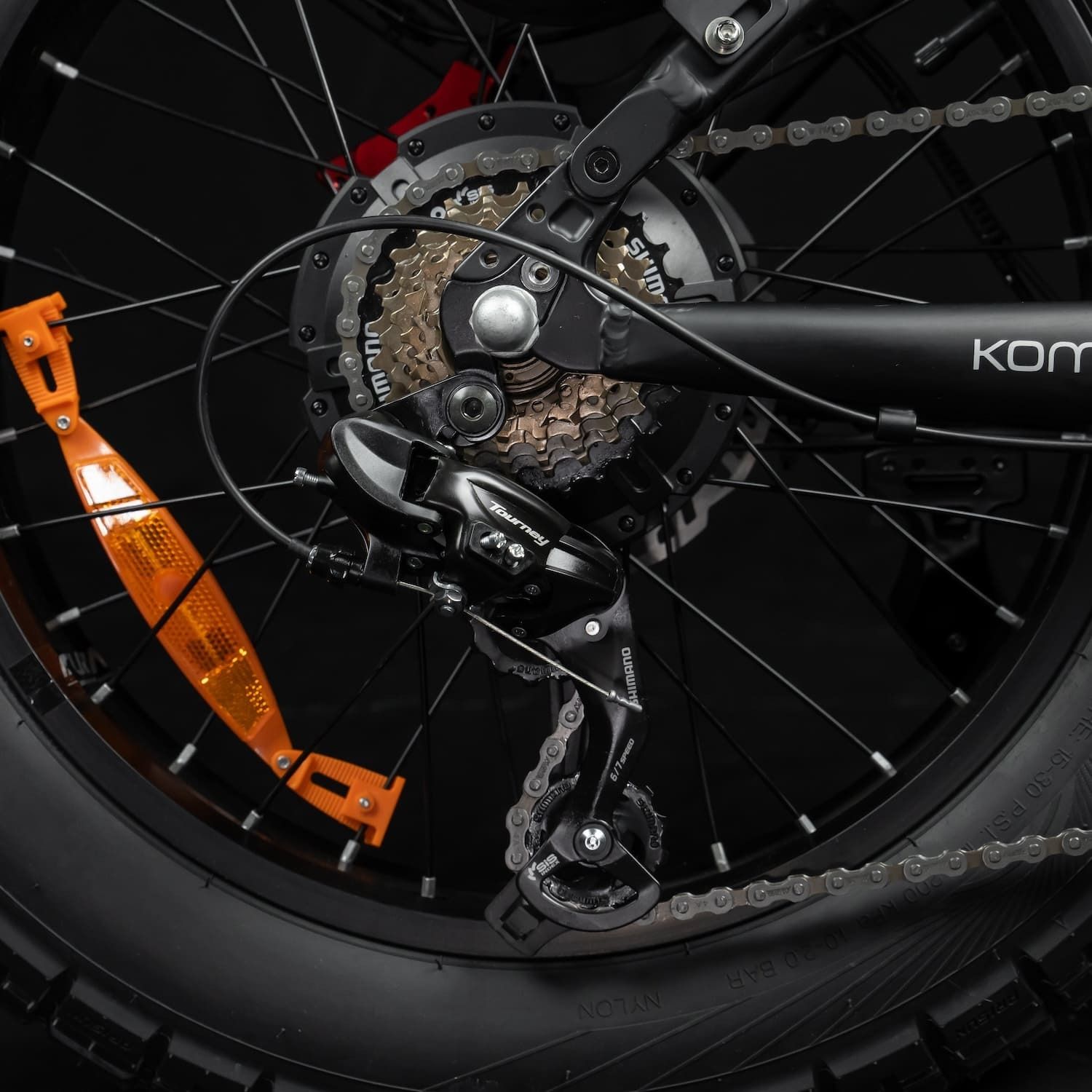 Achterwiel met versnellingen en oranje reflector. Zwarte componenten.