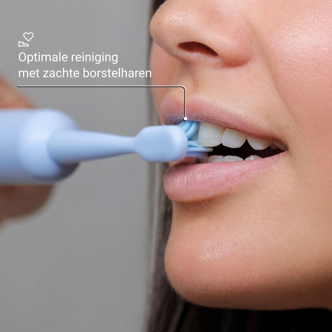 Close-up van een persoon die poetst met een blauwe tandenborstel. Blauwe borstelharen.