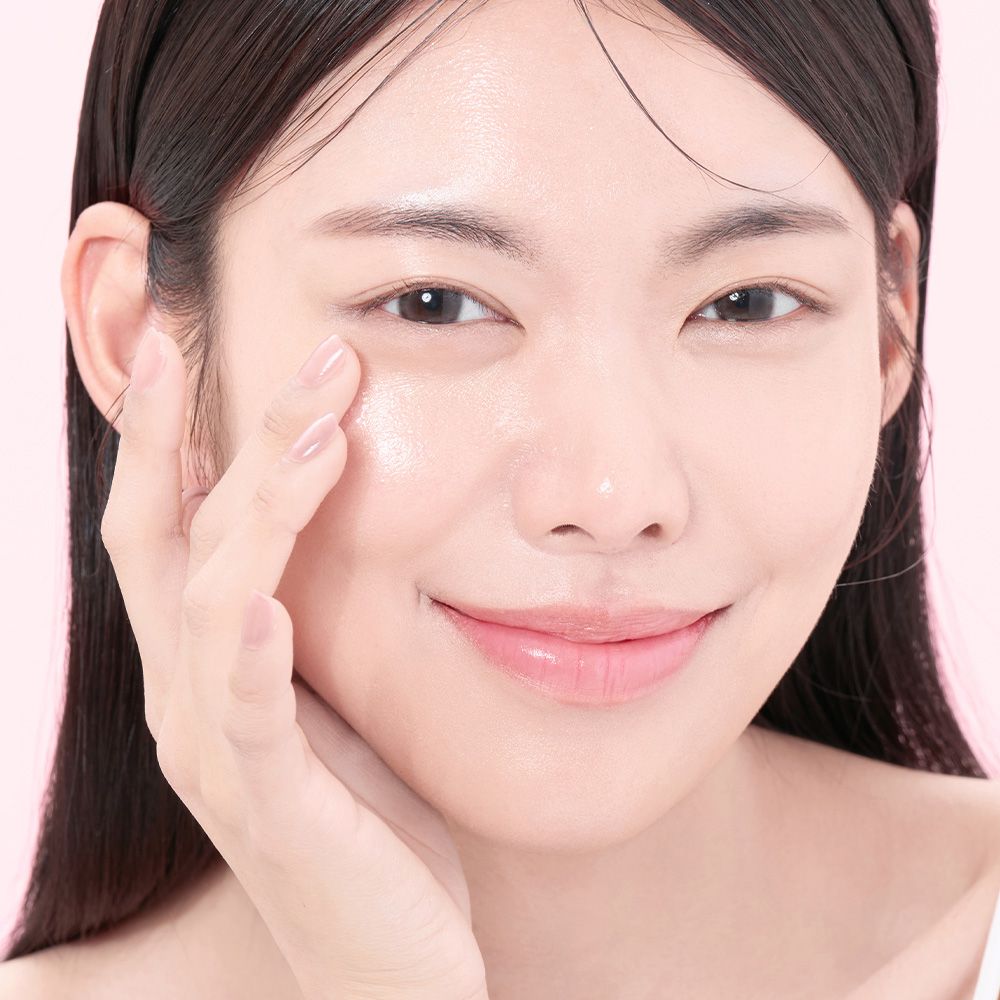 Een vrouw brengt serum aan op haar gezicht, close-up.
